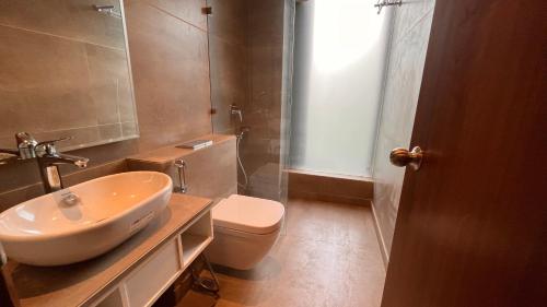 a bathroom with a white sink and a toilet at IP Royal Hotel - New Delhi in New Delhi