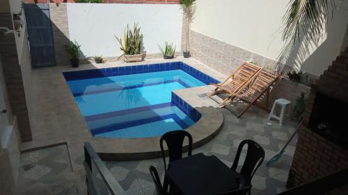 una piscina en un patio trasero con una silla y una mesa en Casa Larithur en Beberibe