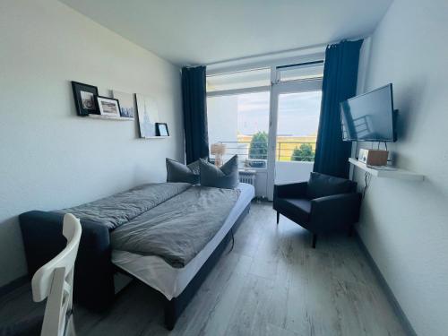 a bedroom with a bed and a chair and a window at Apartment Seesrauschen für 2-4 Personen mit Pool in Dahme