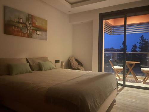 a bedroom with a large bed and a large window at Superbe appartement à l Hivernage in Marrakesh