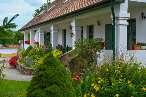 a house with flowers in the front yard at Falubíró Vendégháza in Bekölce