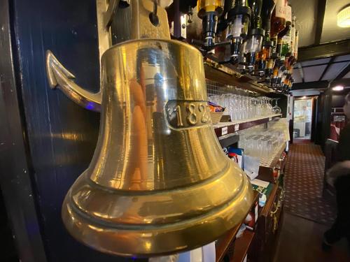 a large gold bell in a bar at The Five Bells, Eastry in Sandwich