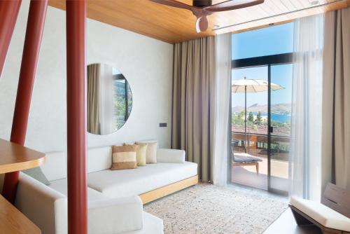 a living room with a white couch and a large window at Birdcage 33 Hotel - Adult Only in Yalıkavak