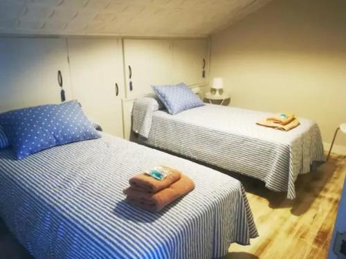 - une chambre avec 2 lits et des serviettes dans l'établissement Montaña y mar, à Vegadeo