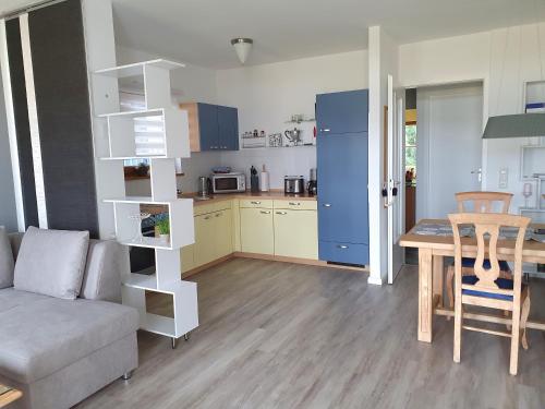 a living room with a couch and a table and a kitchen at Ferienwohnung Am Golfplatz 18 in Wittenbeck