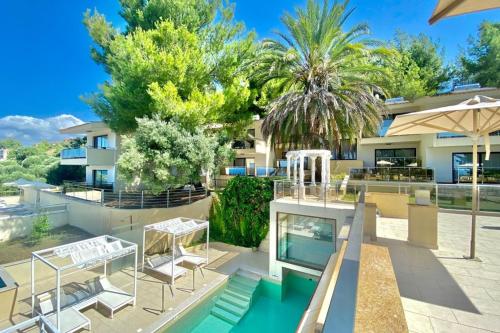 a villa with a swimming pool and a house at Greek Pride Cronwell Rahoni Hotel in Nea Skioni