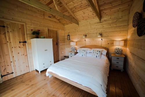 a bedroom with a bed in a wooden cabin at Raleigh Lodge in Bideford