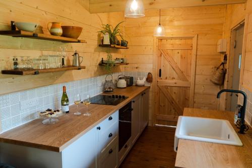 a kitchen with wooden walls and a counter with wine glasses at Raleigh Lodge in Bideford