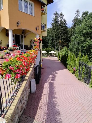 a walkway in front of a building with flowers at Pasja in Świeradów-Zdrój