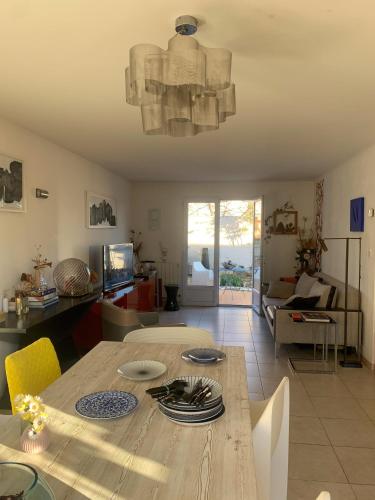 - un salon avec une table en bois et une salle à manger dans l'établissement Bright and quiet house with two gardens north shade and south sun, à La Ciotat