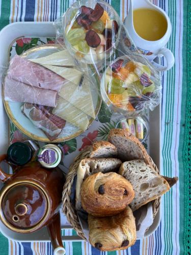 a table with a basket of food and a cup of tea at Maison Périgord vert piscine et spa in La Roche-Chalais