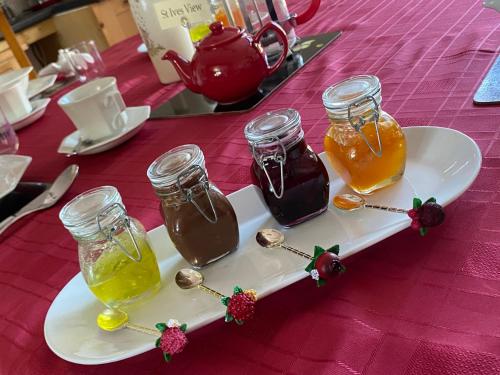 a plate with three jars of honey on a table at Meadowview Cottage, Garden View in Camborne