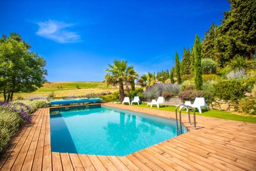 une piscine avec deux chaises blanches et une terrasse en bois dans l'établissement Gîte - Holiday Home Vent Marin, à Limoux
