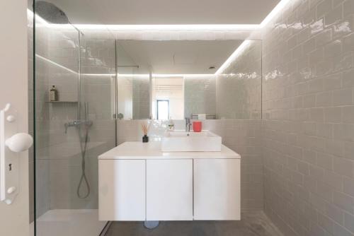 a white bathroom with a sink and a shower at Porto Garden Villa in Porto