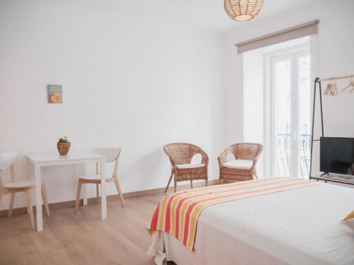 a bedroom with a bed and a table and chairs at Alcácer Central Apartments in Alcácer do Sal