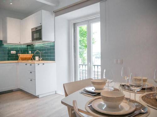 a kitchen and dining room with a table with wine glasses at Alcácer Central Apartments in Alcácer do Sal