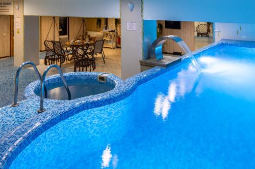 a large blue swimming pool with a water fountain at Hotel Galaktika in Lviv