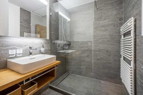 uma casa de banho com um lavatório e um chuveiro em LAAX Homes - Val Signina 1-13a em Laax