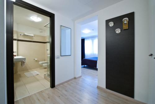 een badkamer met een douche, een toilet en een deur bij Hotel Cajeta in Buia