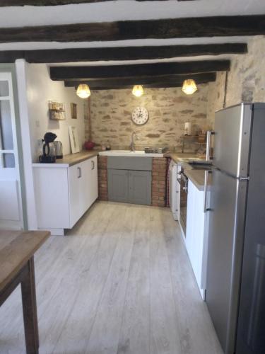 a large kitchen with white appliances and wooden floors at Reids Retreat in La Roche-lʼAbeille