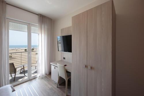 a hotel room with a desk and a view of the ocean at Hotel Monaco in Caorle