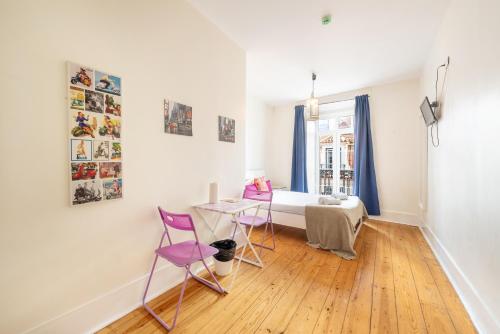 a bedroom with a bed and a table and chairs at Happy at Chiado in Lisbon