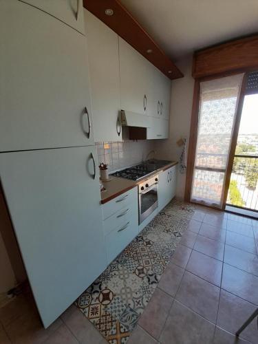una cucina con elettrodomestici bianchi e pavimento piastrellato di A casa di Annamaria a Reggio Emilia
