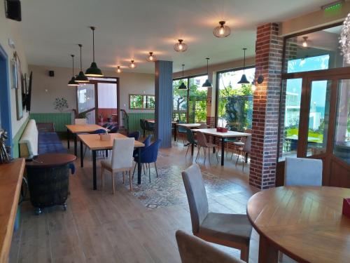 a restaurant with tables and chairs and windows at St. George Guest House in Sveti Vlas
