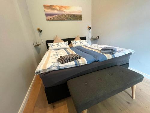 Un dormitorio con una cama con un banco al lado en Gästehaus Sternschanze - App1 Admiral, en Stralsund