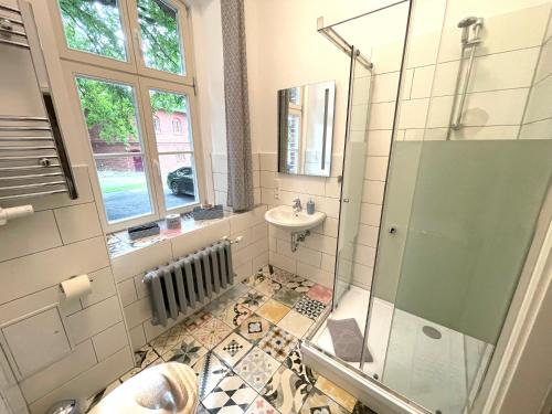 a bathroom with a shower and a sink and a mirror at Gästehaus Sternschanze - App1 Admiral in Stralsund