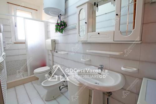 a bathroom with a sink and a toilet and a mirror at GD Case Vacanza - Fronte Mare - in Lido Marini