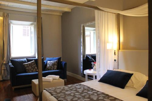 a bedroom with a bed and a couch and a mirror at Hotel Charleston in Spoleto