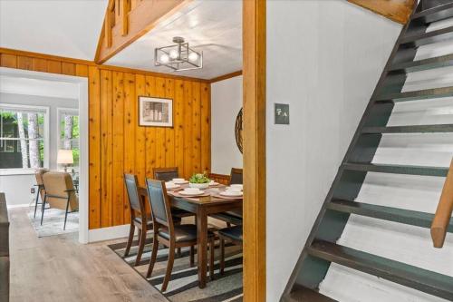 a dining room with a table and chairs and a staircase at The Gingerbread House: 4 BR chalet, w/ Sunroom/Deck, sleeps 12, modern amenities in McGaheysville