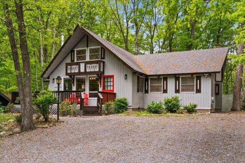 a small house with a red door in the woods at The Gingerbread House: 4 BR chalet, w/ Sunroom/Deck, sleeps 12, modern amenities in McGaheysville