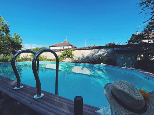 une piscine avec deux barres métalliques autour de celle-ci dans l'établissement Le Val Clos, appartement dans une maison de maître 19e, à Tanlay