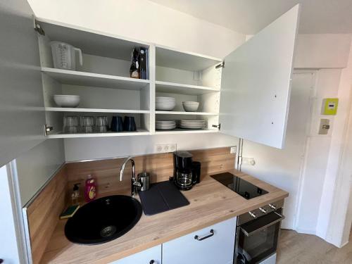 a kitchen with a sink and white cabinets at Appartement Centre ville Le Havre in Le Havre