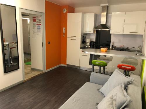 a living room with a couch and a kitchen at Résidence Pierre François in La Roche-sur-Yon