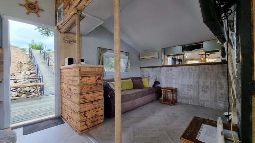 a living room with a couch and a large window at Splav na dan Waterhouse in Belgrade