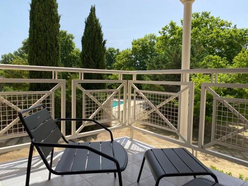 une paire de chaises et une table sur une terrasse dans l'établissement Domaine de la Reynaude, à Aurons