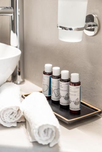 three bottles of medicine sitting on a tray in a bathroom at Dioni Villa Mykonos in Paraga