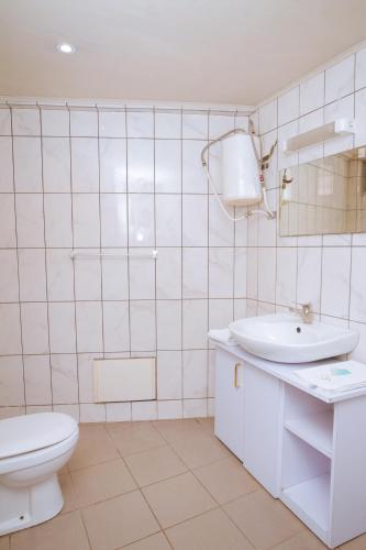 a white bathroom with a toilet and a sink at RESIDENCE OLIE OFFICIEL in Douala