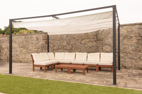 a group of white benches under a white canopy at Pazo de San Pedro de Bembibre in Taboada