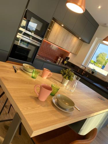 a kitchen with a wooden table with dishes on it at Ker Melen in Cléder