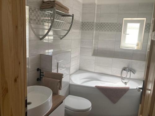 a bathroom with a tub and a toilet and a sink at Rezidencia Podhájska in Podhájska