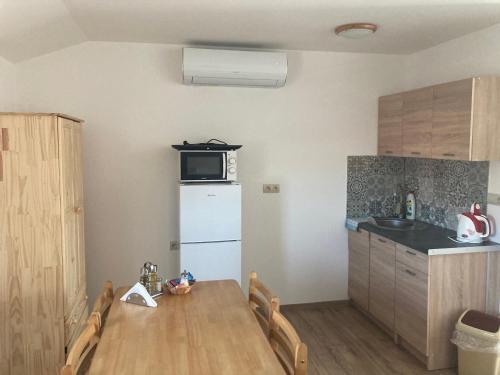 a small kitchen with a table and a microwave at Rezidencia Podhájska in Podhájska