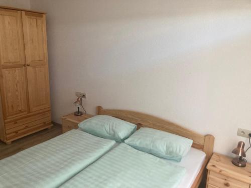 a bedroom with a bed and two pillows at Rezidencia Podhájska in Podhájska