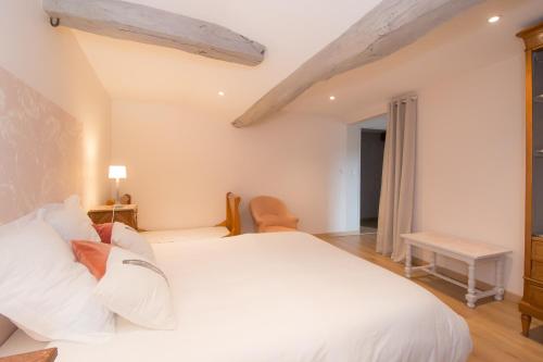 een slaapkamer met een groot wit bed met witte kussens bij Moulin du Ruet in Saint-Amand-sur-Fion