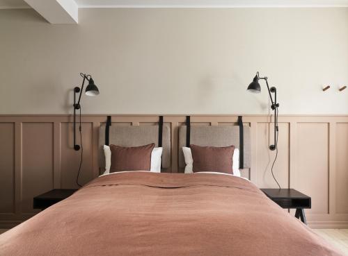 a bedroom with a large bed with two lamps on it at 46heima Boutique Apartments in Reykjavík