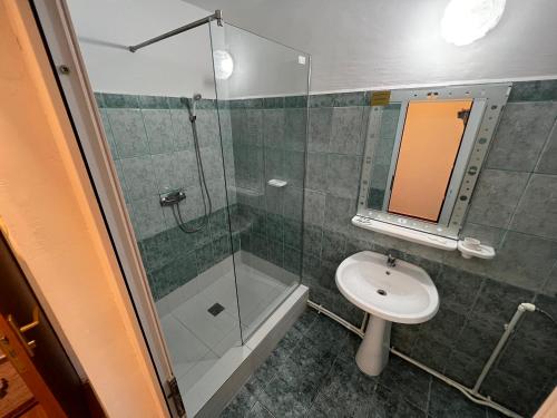 a bathroom with a glass shower and a sink at Claudia in Eforie Sud