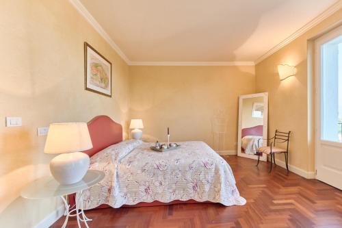 a bedroom with a bed with a table and a lamp at Villa Ardea in Soiano del Lago